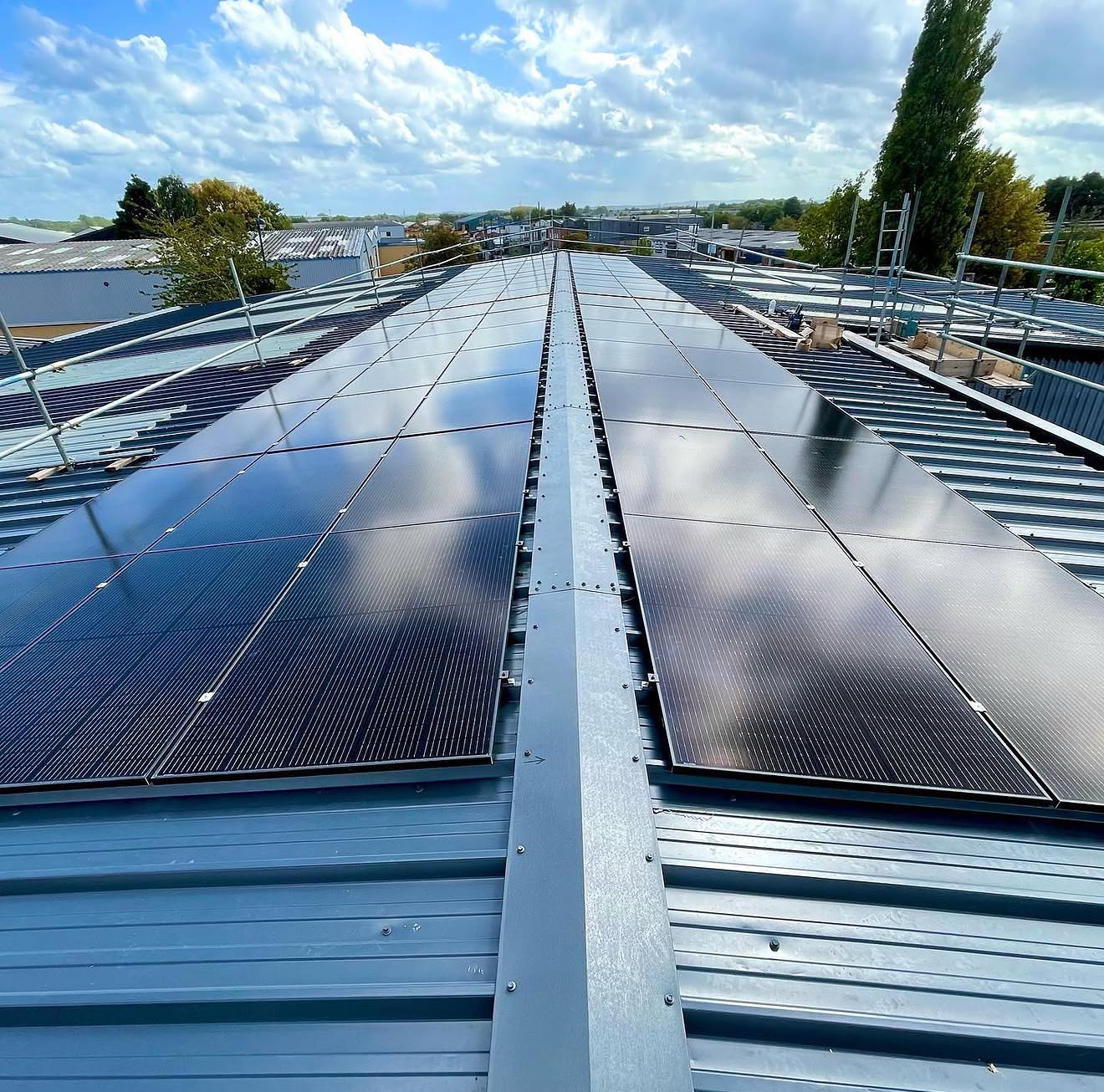 Long rows of solar panels on a corrugated commercial roof