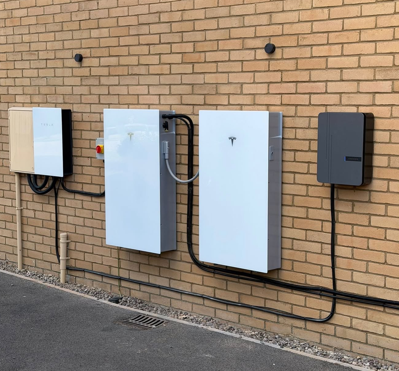 Whole-home battery setup with gateway and backup equipment on a brick wall