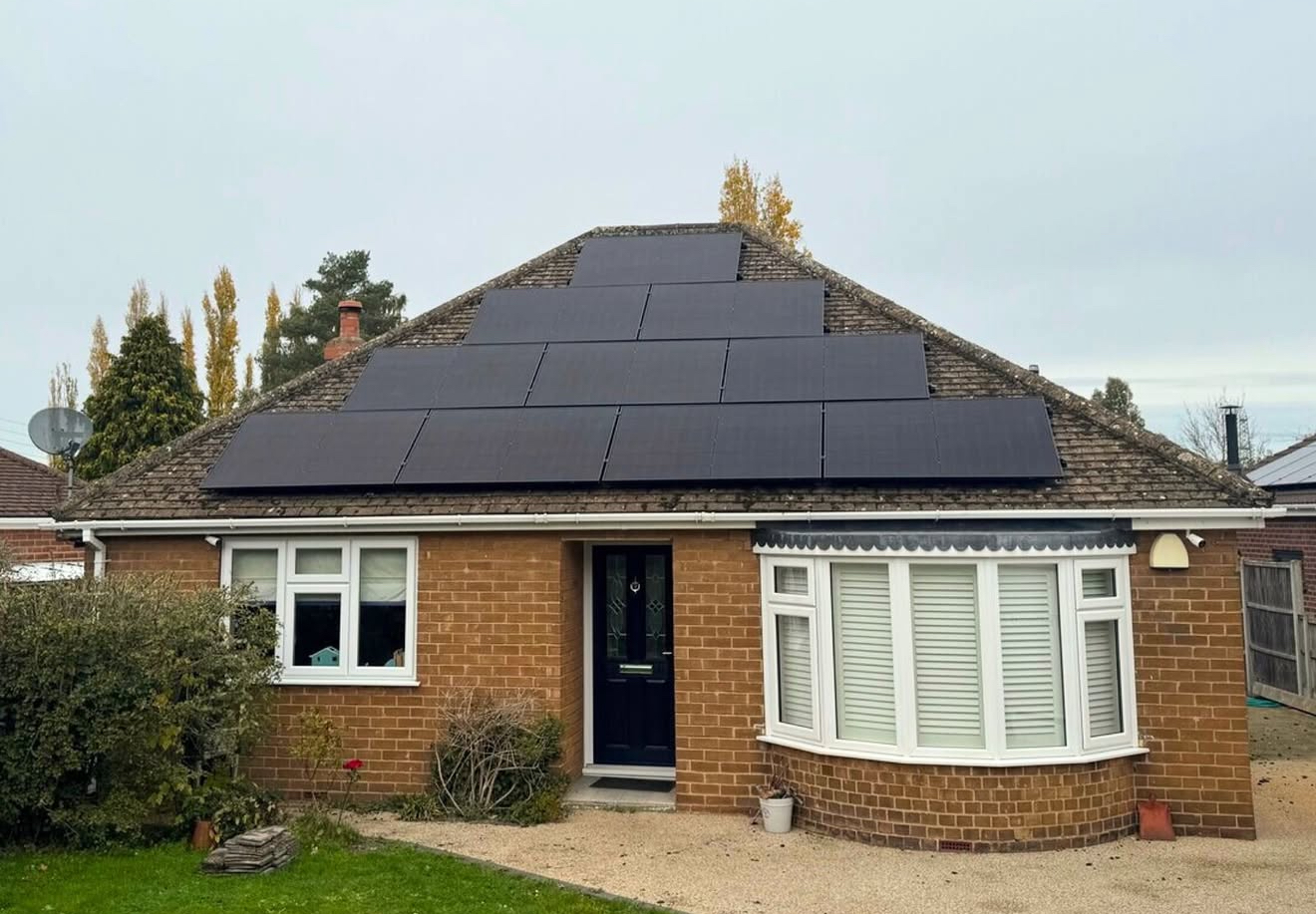 Bungalow with a full set of black solar panels on a tiled hip roof